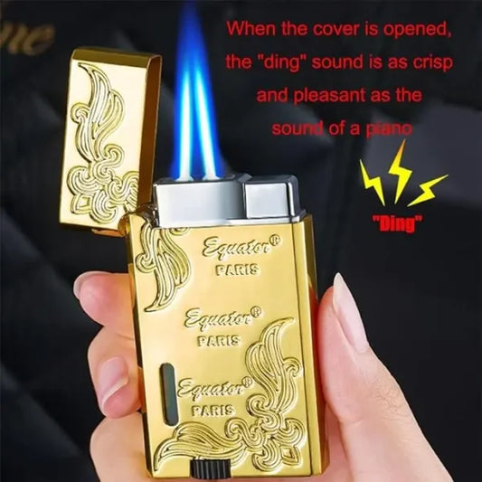 Gold lighter with decorative design held by a hand, against a dark background.
