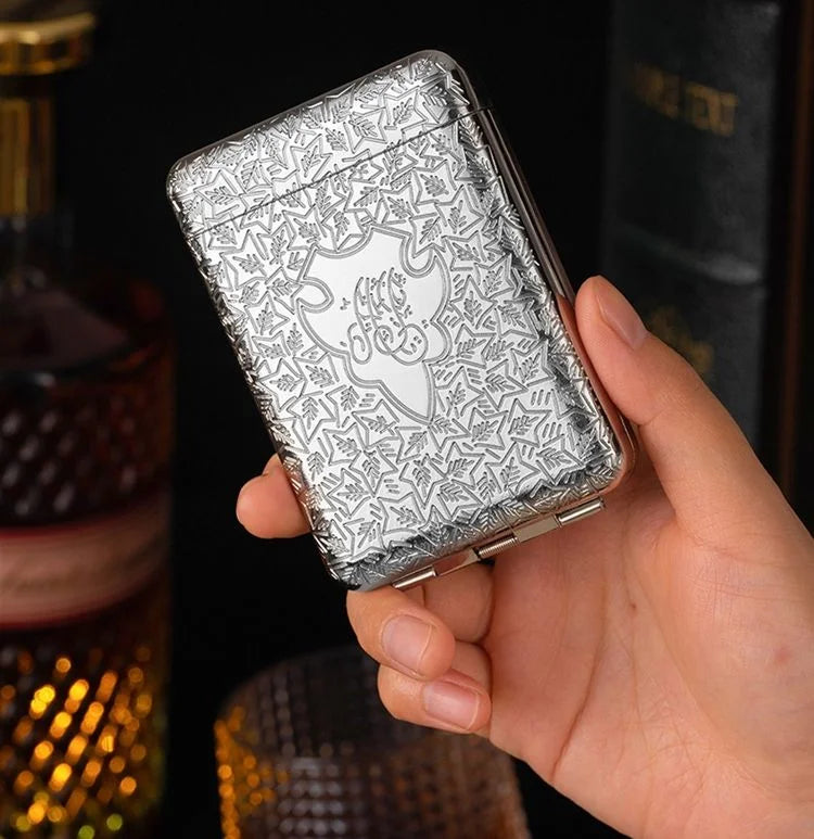 Hand holding a silver embossed cigarette case with a blurred background