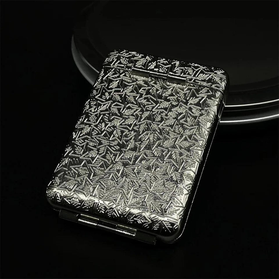 Silver metallic Cigarette Holder with intricate pattern on a black background