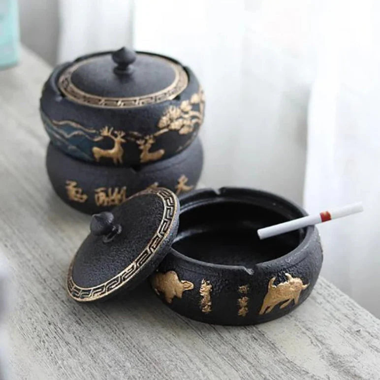 Black ceramic Ashtray with gold designs on a light surface
