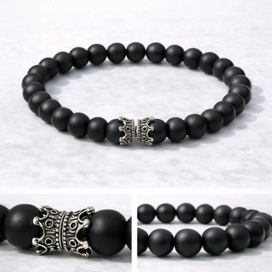 Black beaded bracelet with a silver crown-shaped clasp on a light gray background