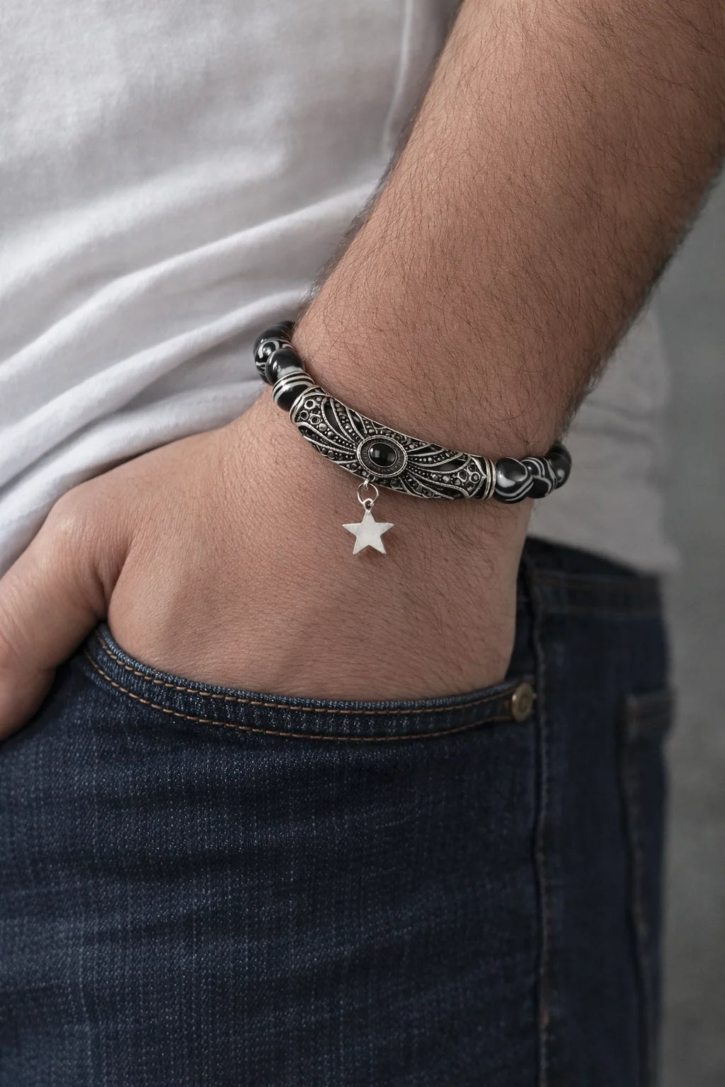 Close-up of a person's wrist wearing a detailed bracelet with a star charm.