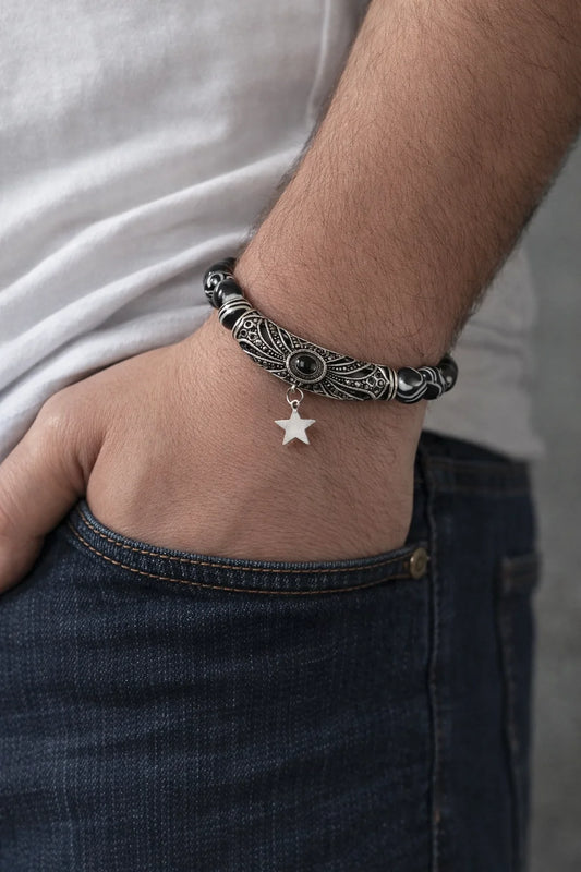Close-up of a person's wrist wearing a detailed bracelet with a star charm.