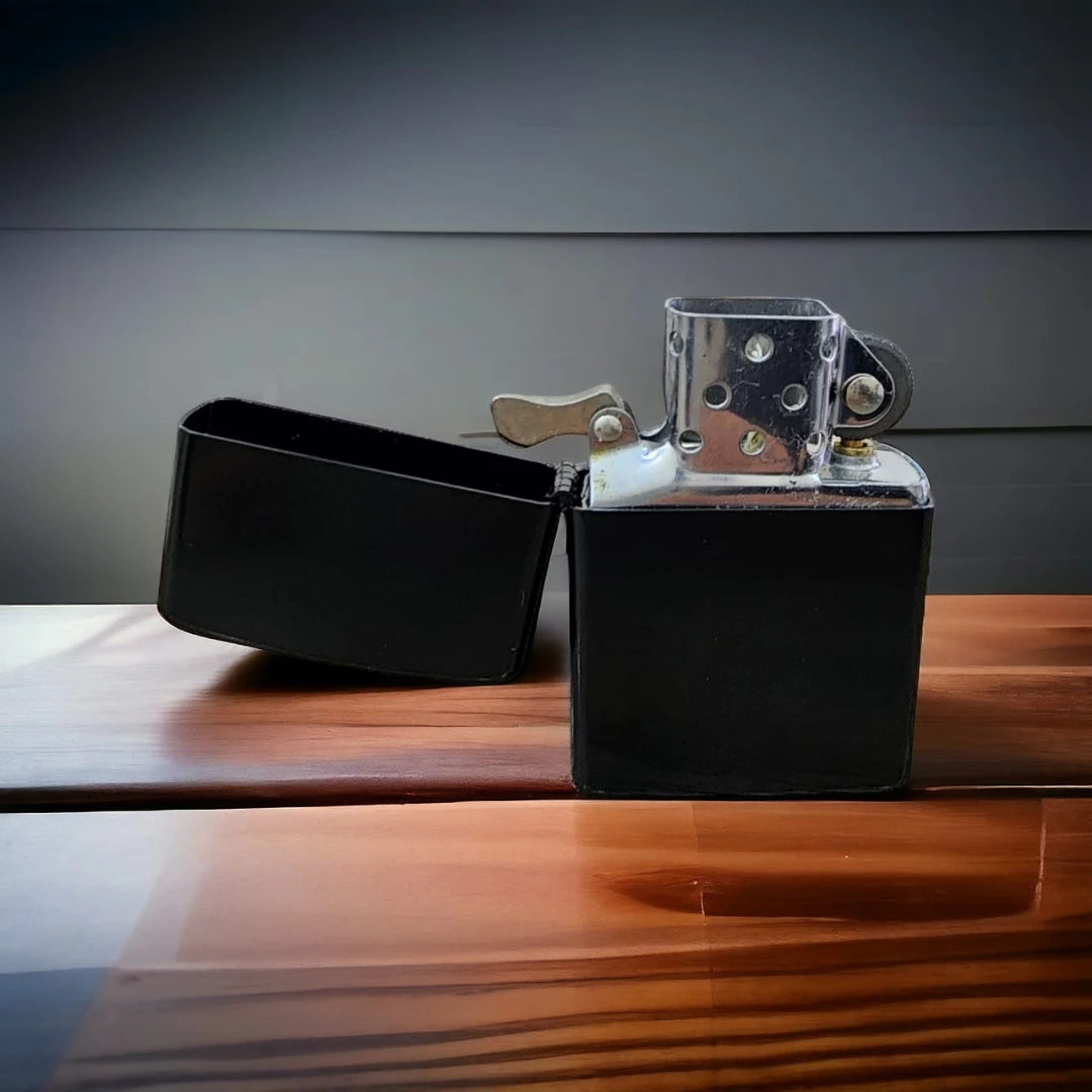 Black Zippo lighter on a wooden surface with a gray background