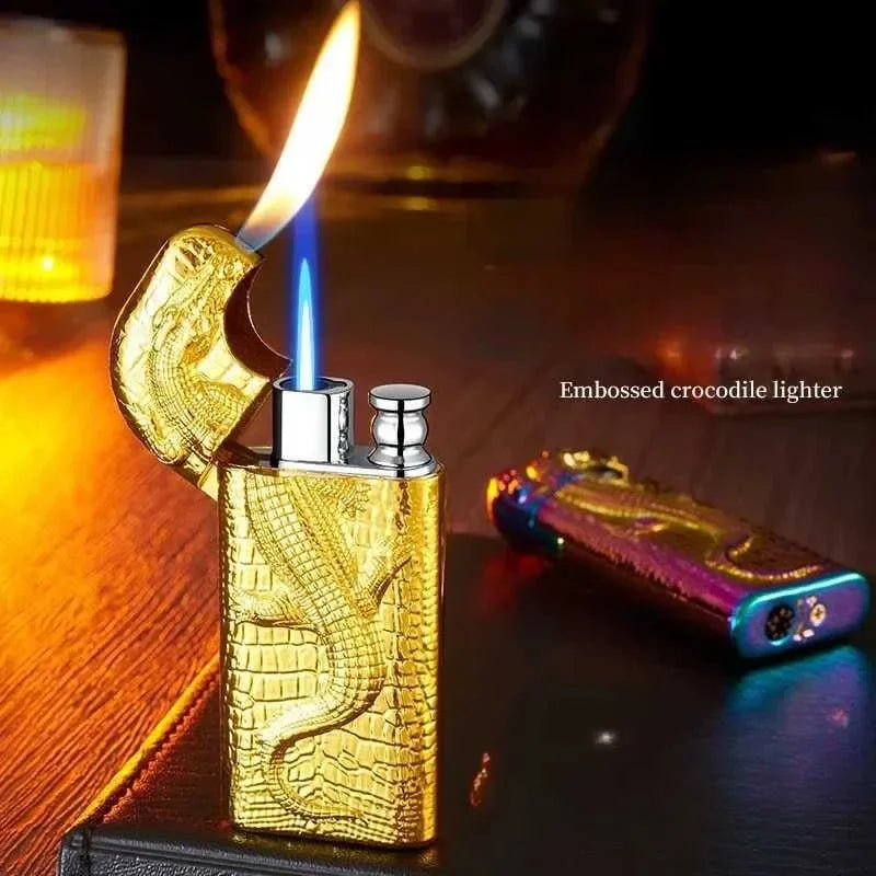 Gold embossed crocodile lighter with a lit flame on a wooden surface.