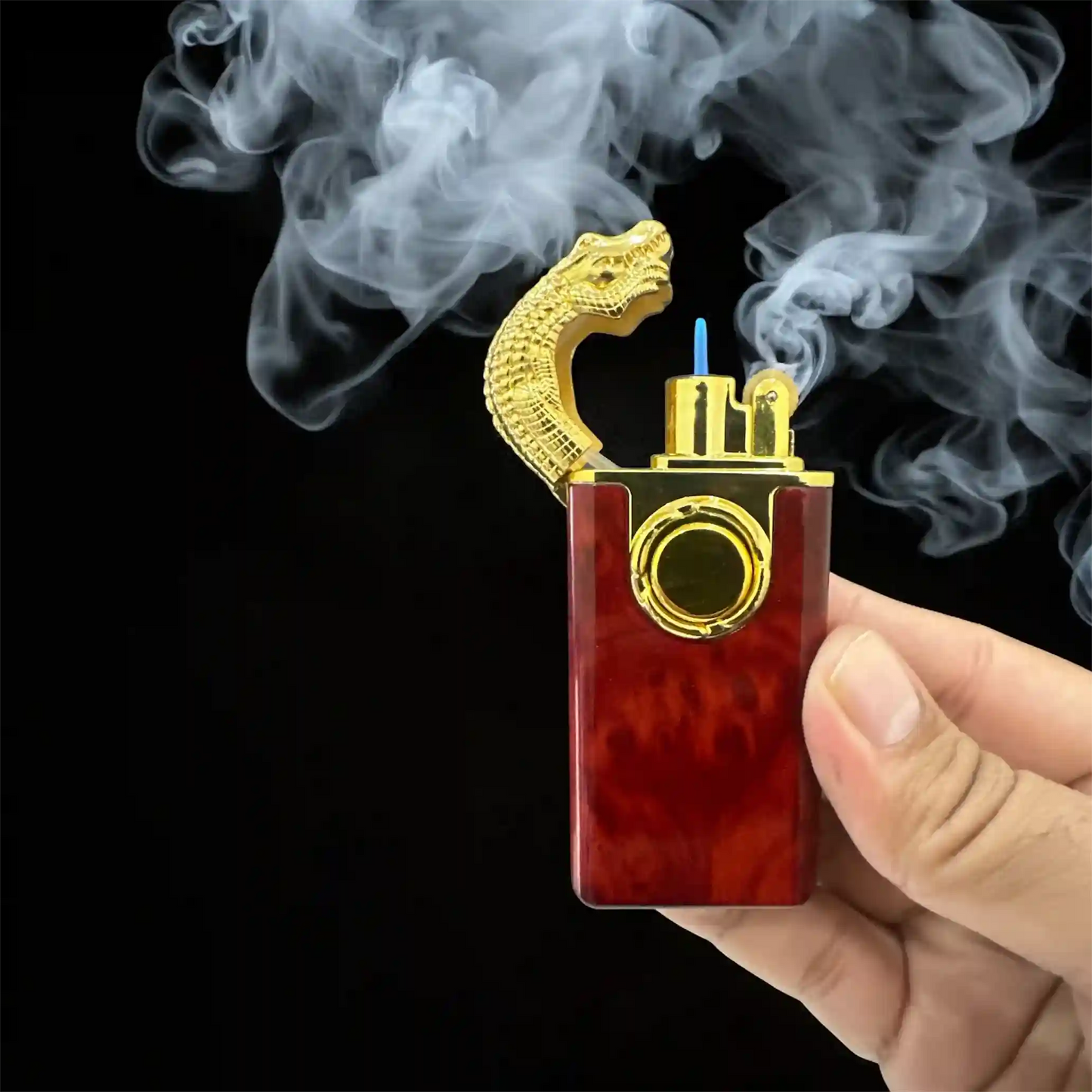 lighter with gold accents and red body, emitting smoke on a black background