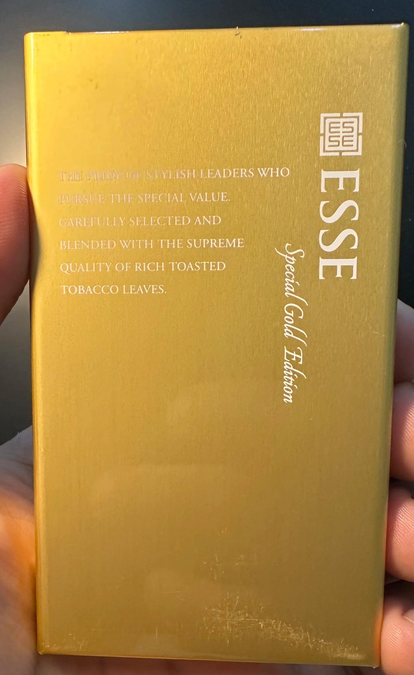Gold-colored product packaging with 'ESSE' branding