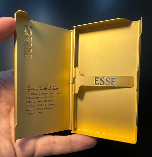 Esse Special Gold Edition cigarette pack held by a hand with a dark background