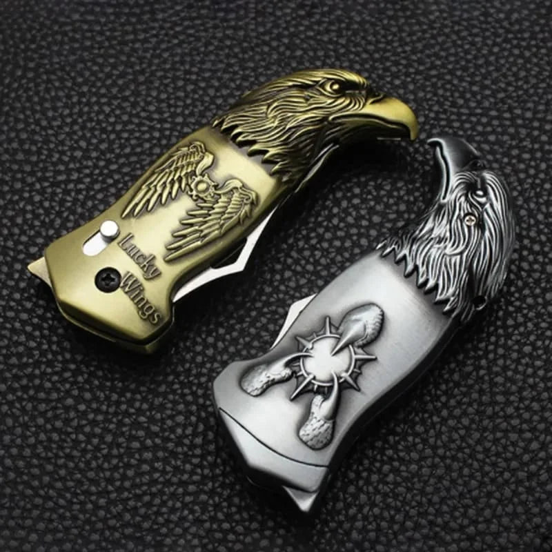 Two metallic keychains with eagle designs on a textured black surface