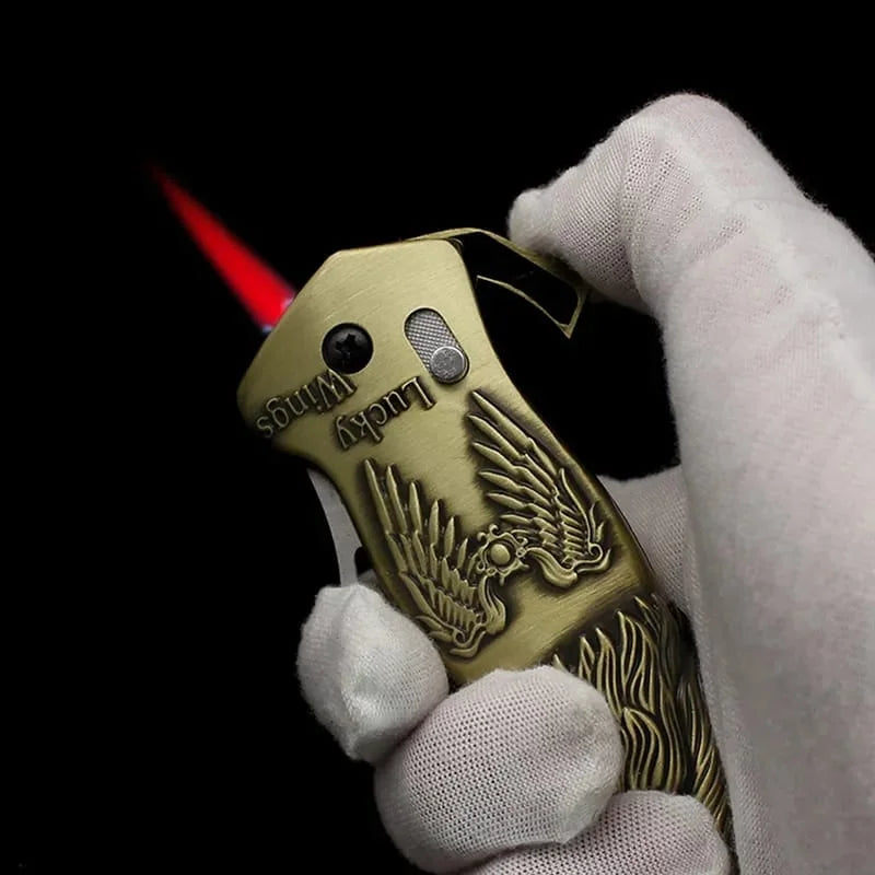 Gold lighter with eagle design held by a gloved hand against a black background