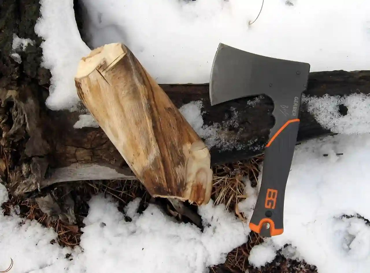 Axes and chopped wood on a snowy ground