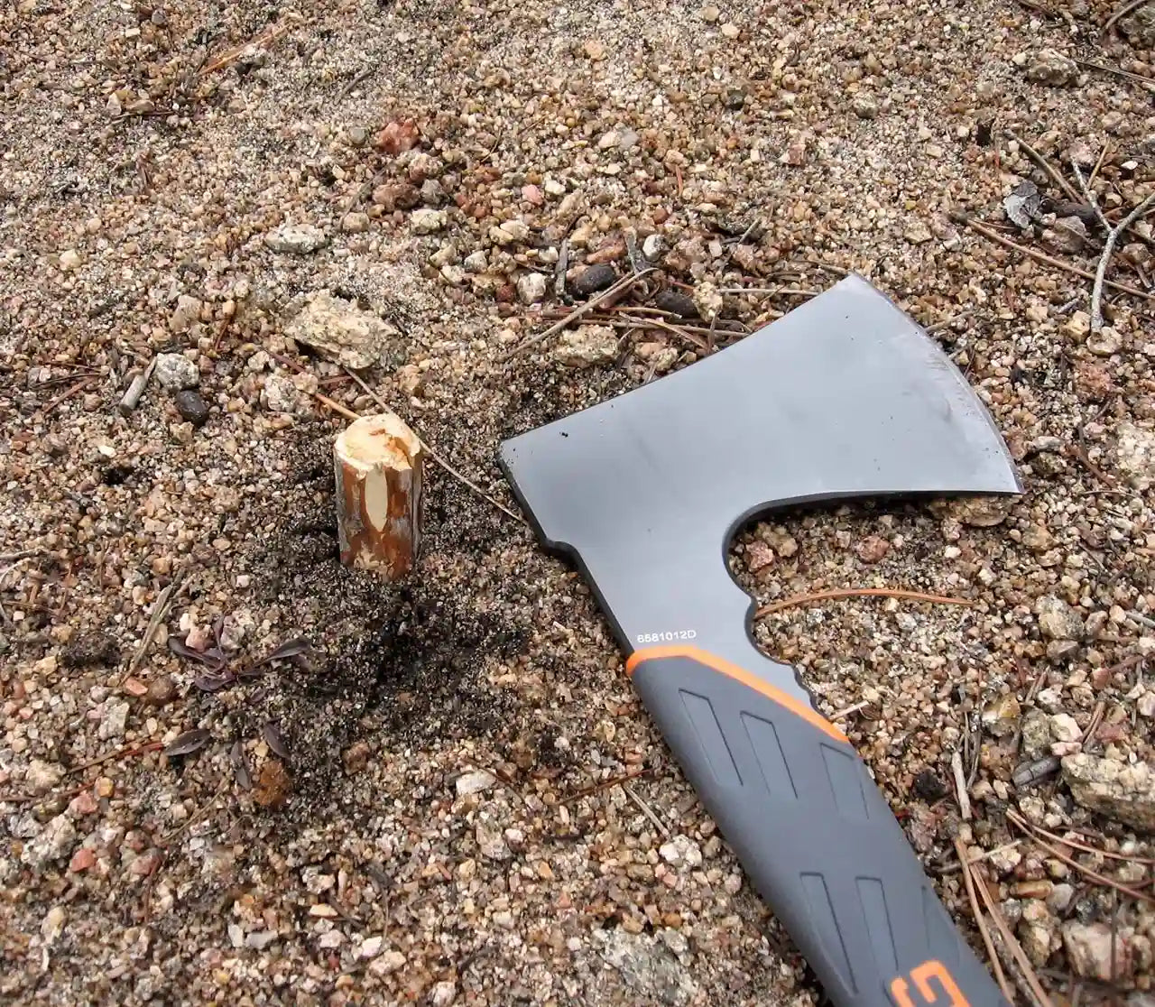 Axes with a stump on a dirt ground