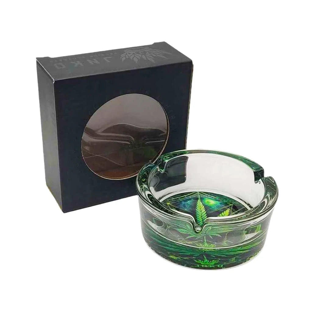 Glass ashtray with green leaf design in front of a black box