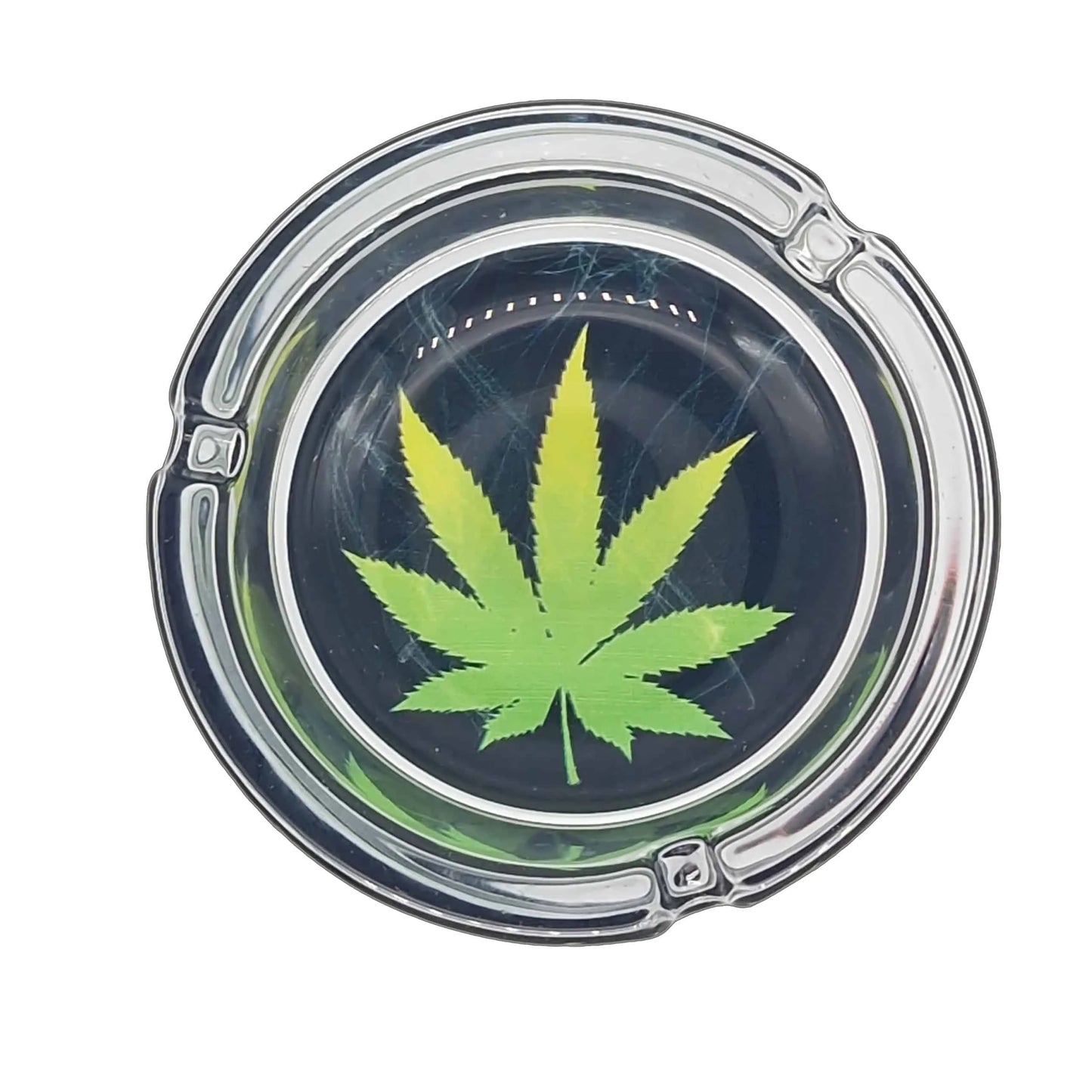 Clear glass ashtray with a green cannabis leaf design on a white background