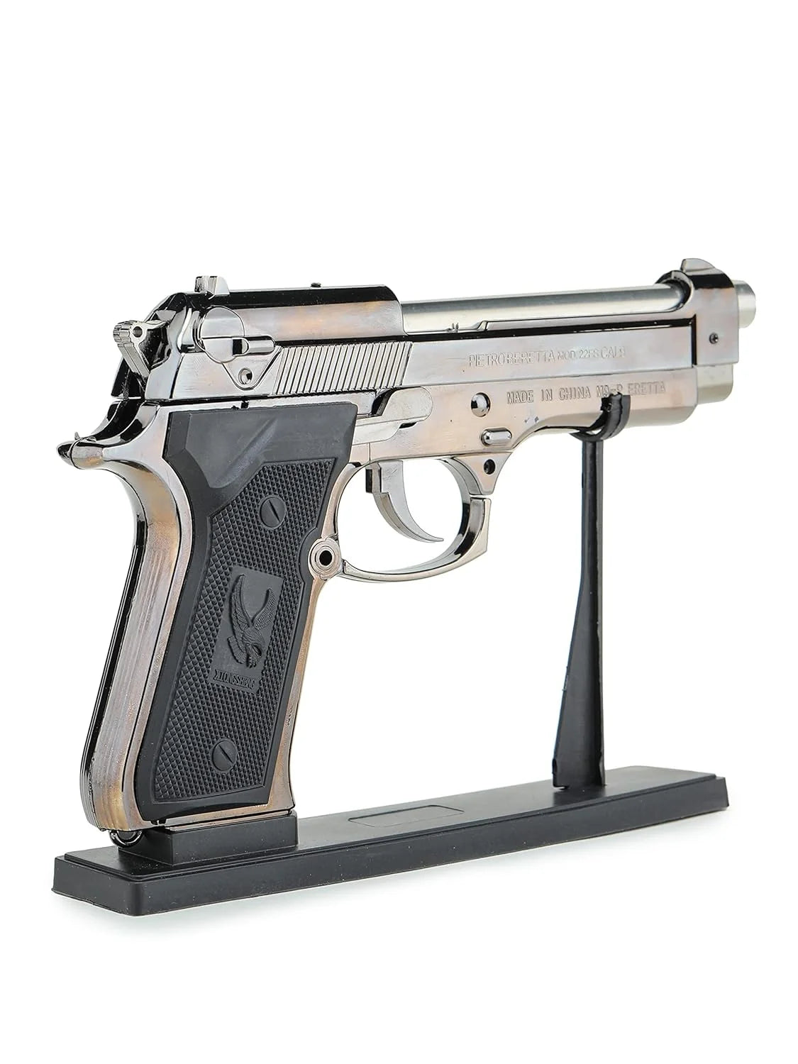 Metallic handgun lighter on a black stand against a white background 