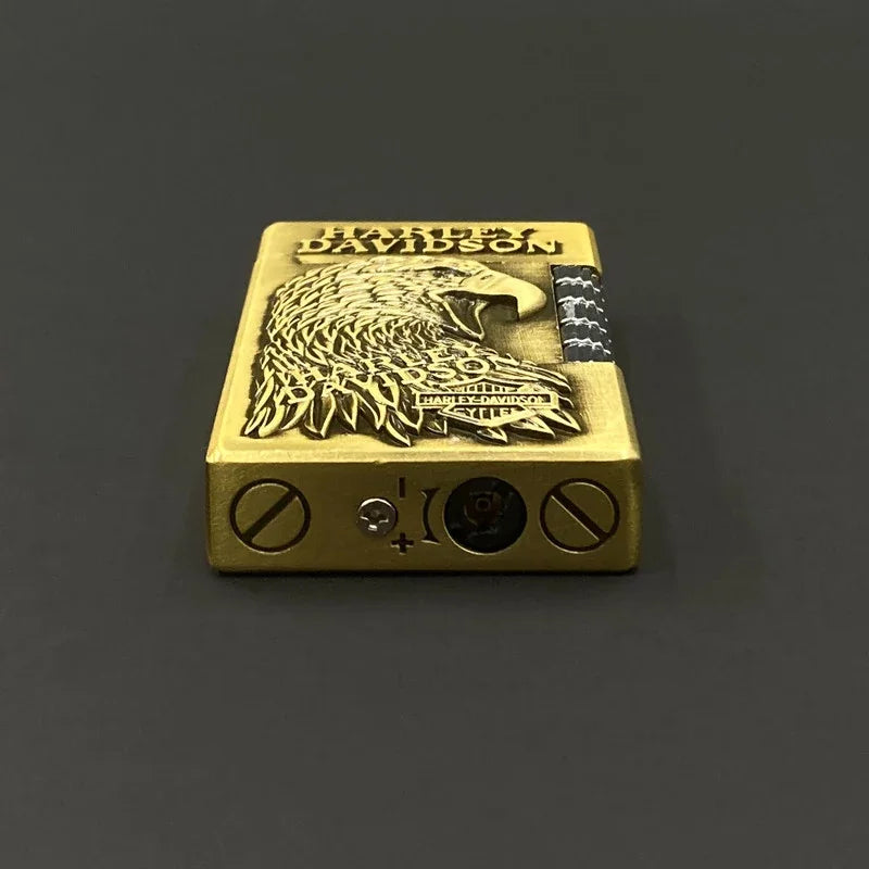 A Harley-Davidson branded lighter with an embossed eagle design and brand name, shown on a dark gray background.