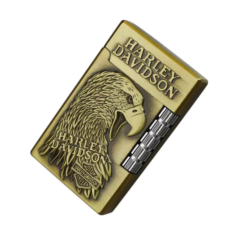A Harley-Davidson branded lighter with an antique bronze finish, featuring an embossed eagle head and the brand name, shown on a plain white background.