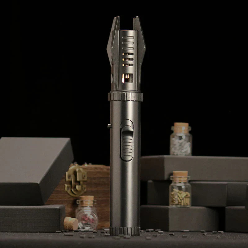 Metallic lighter on a dark background with small jars and boxes.