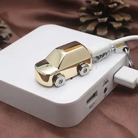 Gold car-shaped keychain  Lighter attached to a white USB hub on a brown fabric background