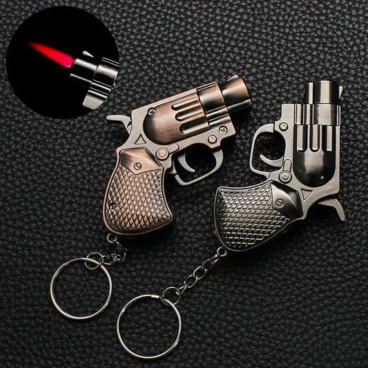 Two gun-shaped Lighter with keychains on a textured black background