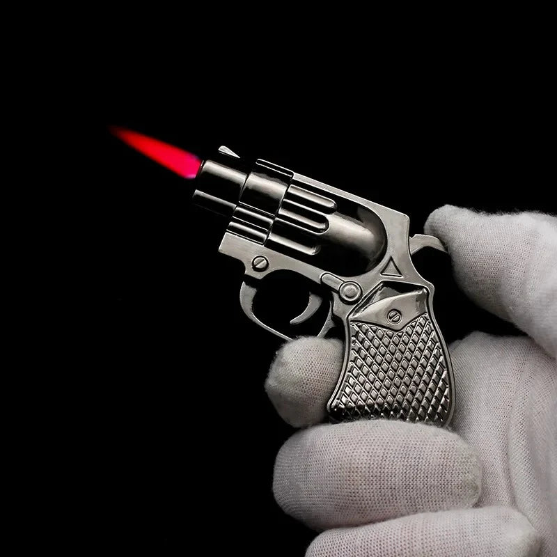 Revolver-shaped lighter with a red flame held in a hand against a black background