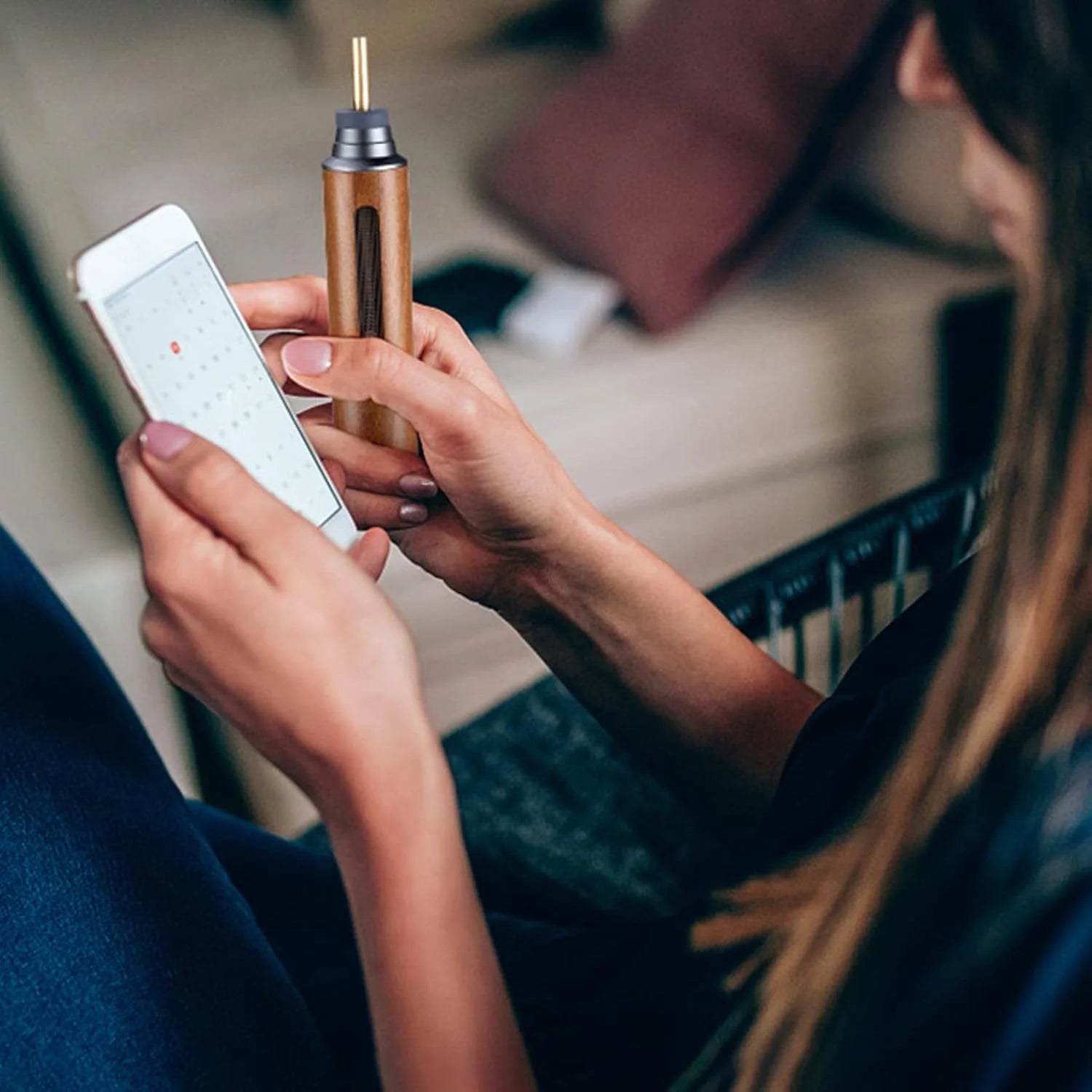 Person holding a smartphone and a wooden portable mini car ashtray in an indoor setting.
