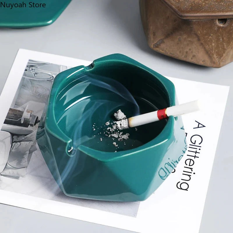 Teal geometric ashtray with a cigarette inside on a magazine
