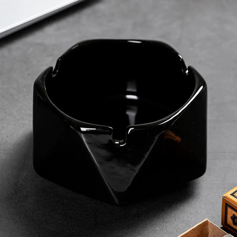 Black ceramic ashtray on a gray surface