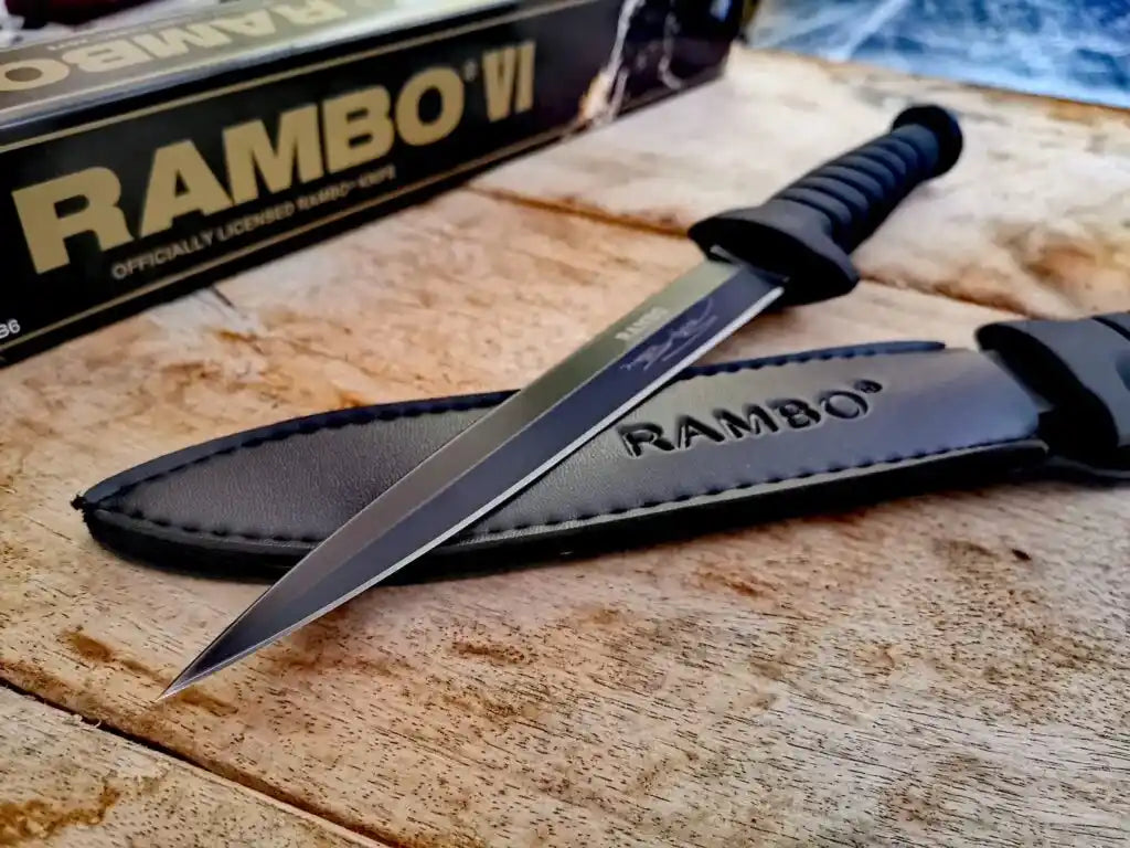 Knife with sheath branded 'Rambo' on a wooden surface