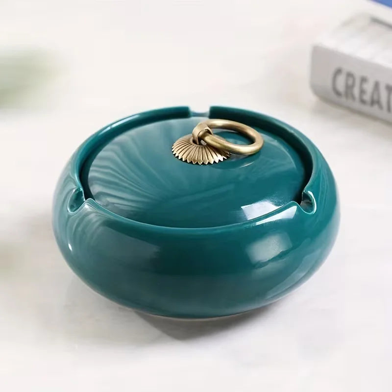 Teal ceramic Ash tray with a gold ring on a white surface