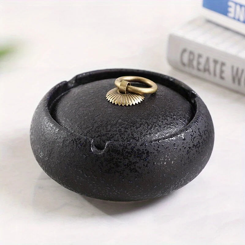 Black stone Ashtray with a gold ring on a white surface