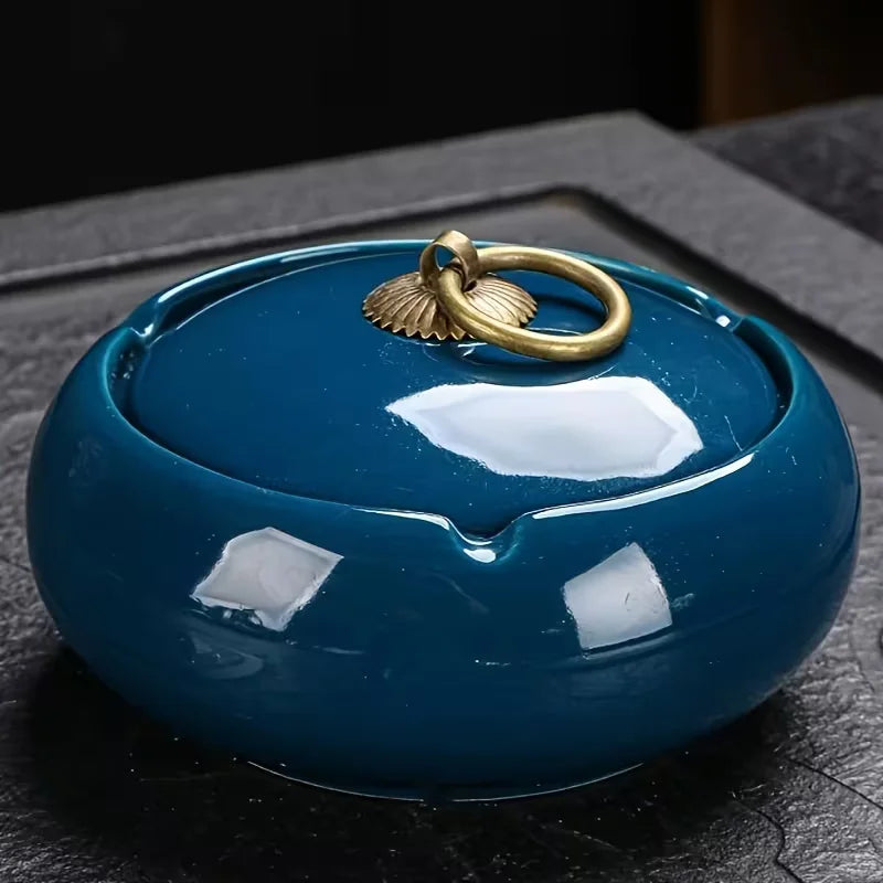Blue ceramic Ashtray with a gold ring on a dark surface