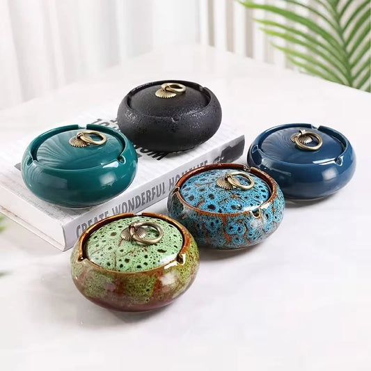 Five ceramic Ashtray with lids in various colors on a white surface.