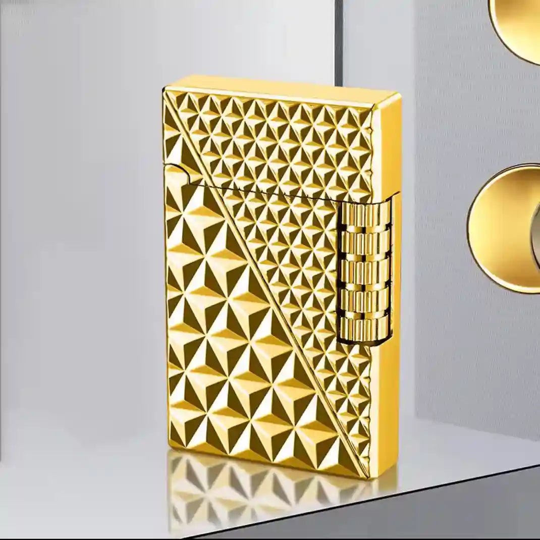 Gold lighter with geometric pattern on a white surface