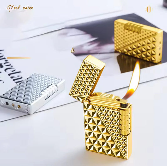 Gold lighter with geometric pattern on a white surface