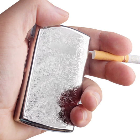 Hand holding a silver case with intricate designs on a white background