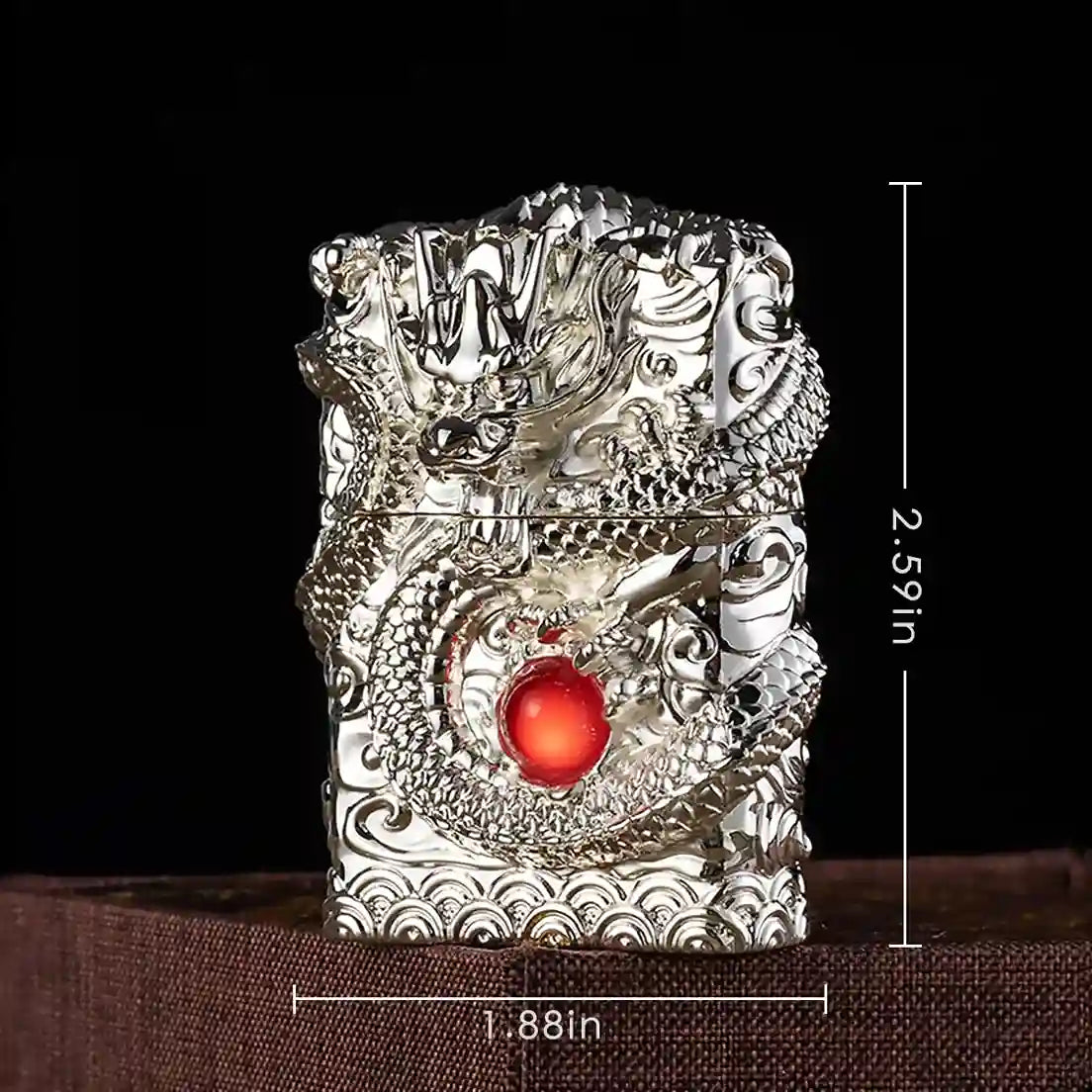 Decorative lighter with dragon design and red gemstone, shown with dimensions on a dark background.