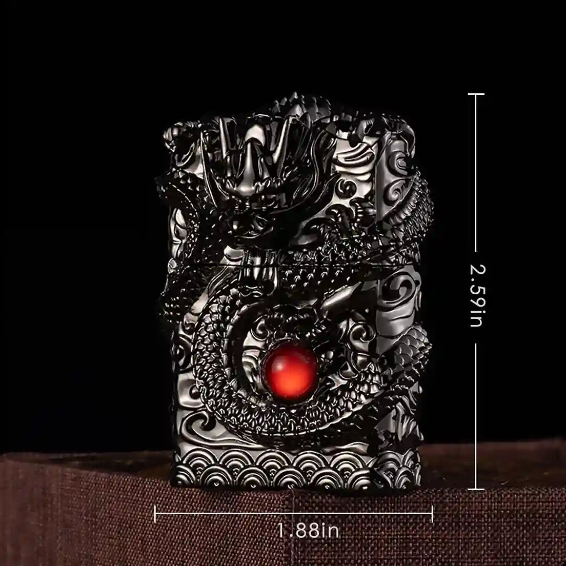 Decorative object with dragon design and red gemstone, shown with measurements on a dark background.