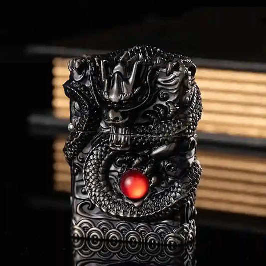 Decorative object with dragon design and red gemstone on a dark background